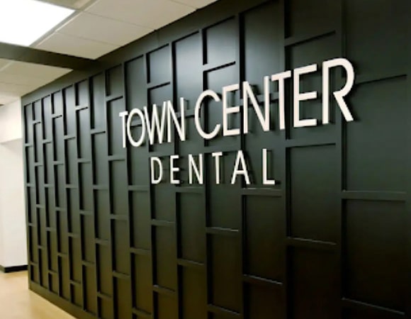 Town Center Dental signage on dark wall in modern dental office entrance