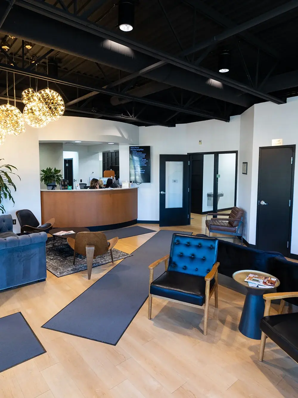 Modern dental office reception area with curved wooden desk, comfortable seating, and professional decor in Flint, MI.