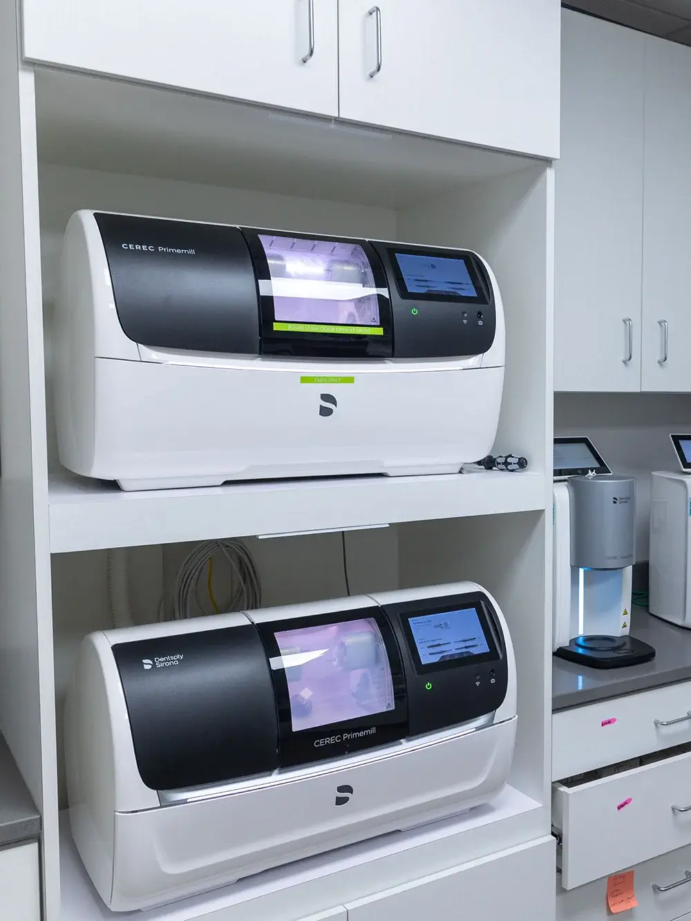CEREC Primermill dental milling machines in laboratory cabinet at Flint dental practice.