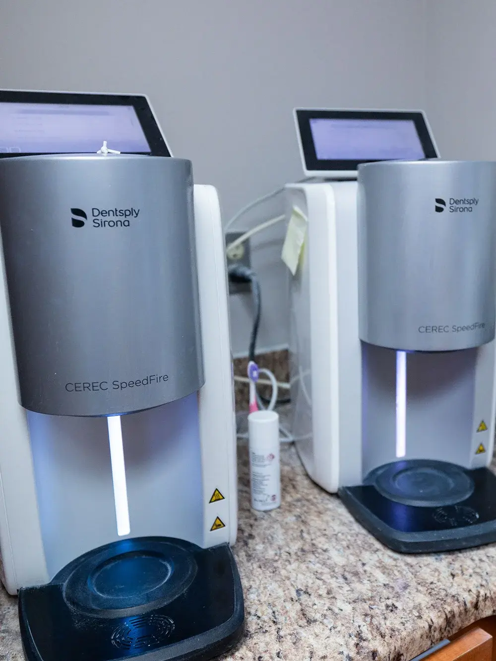 Dentsply Sirona CEREC SpeedFire digital dental scanning and milling equipment in a dental practice.