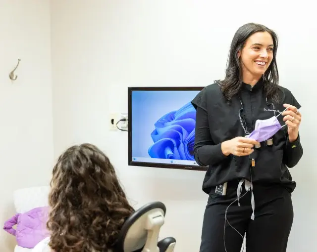 Dr. Summer explains a dental procedure to a patient in the treatment room.