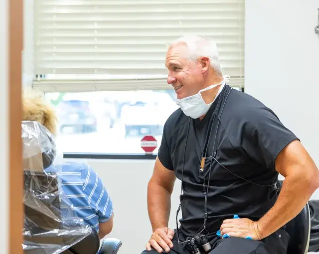 Dr. Timothy consults with a patient in a dental treatment room in Flint, MI.