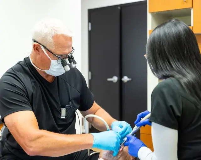 Dentist Dr. Timothy examines a patient's teeth during a dental procedure in Flint.