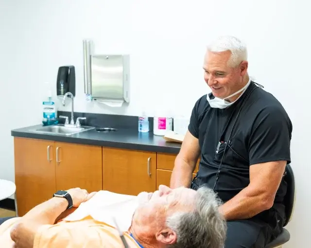 Dr. Timothy treats a patient in a modern dental treatment room in Flint, MI.