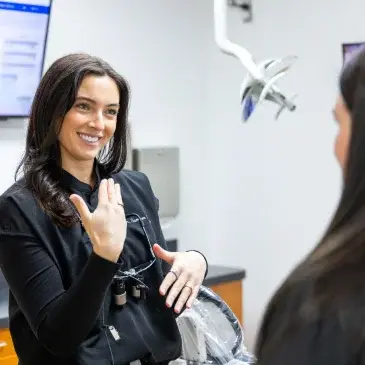 Dentist discussing cosmetic dental treatment options with a patient in a modern dental office.