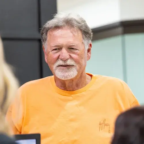 Mature male patient smiling during restorative dentistry consultation in dental office.
