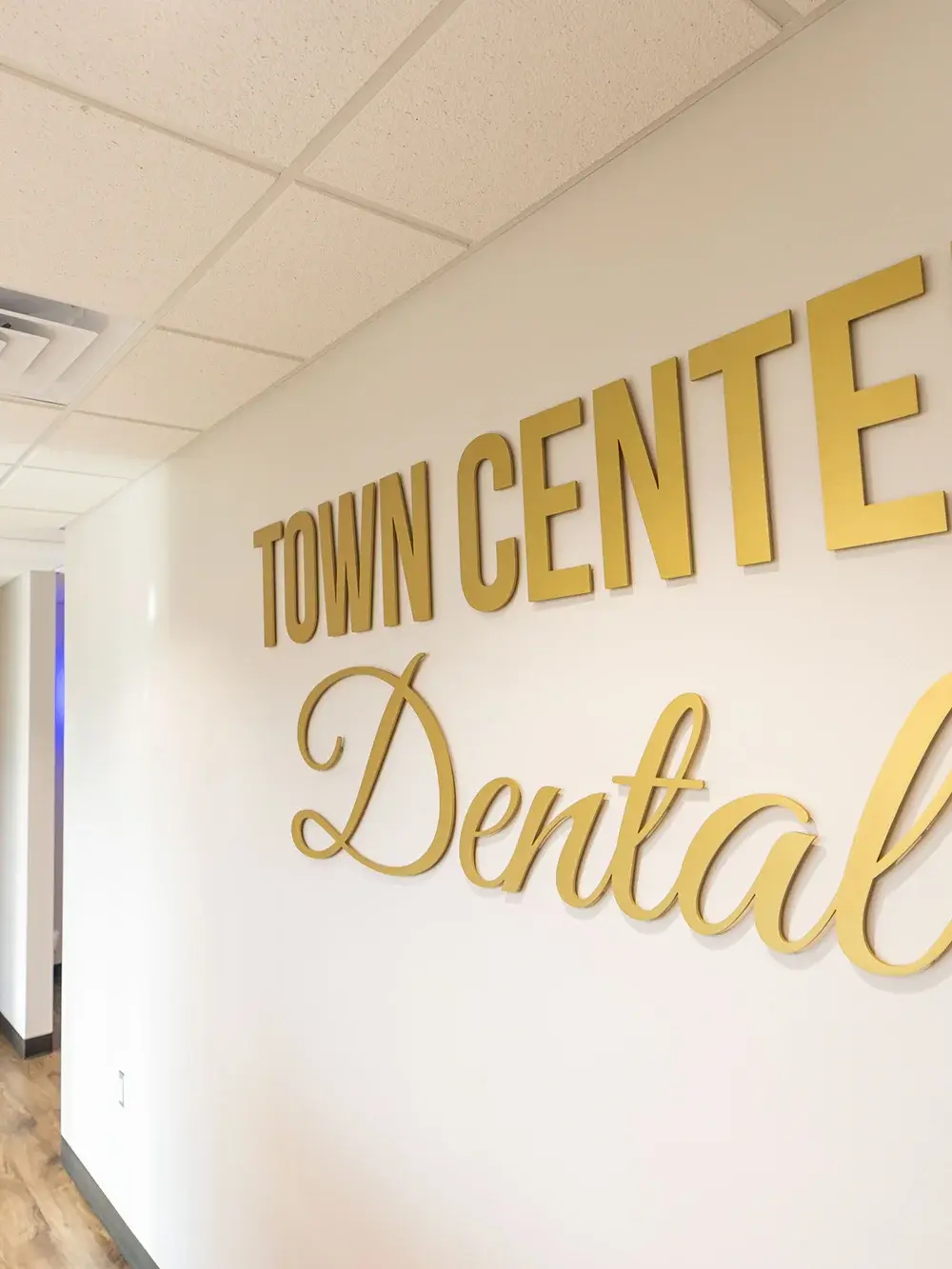 Town Centre Dental gold signage on interior wall of dental office.