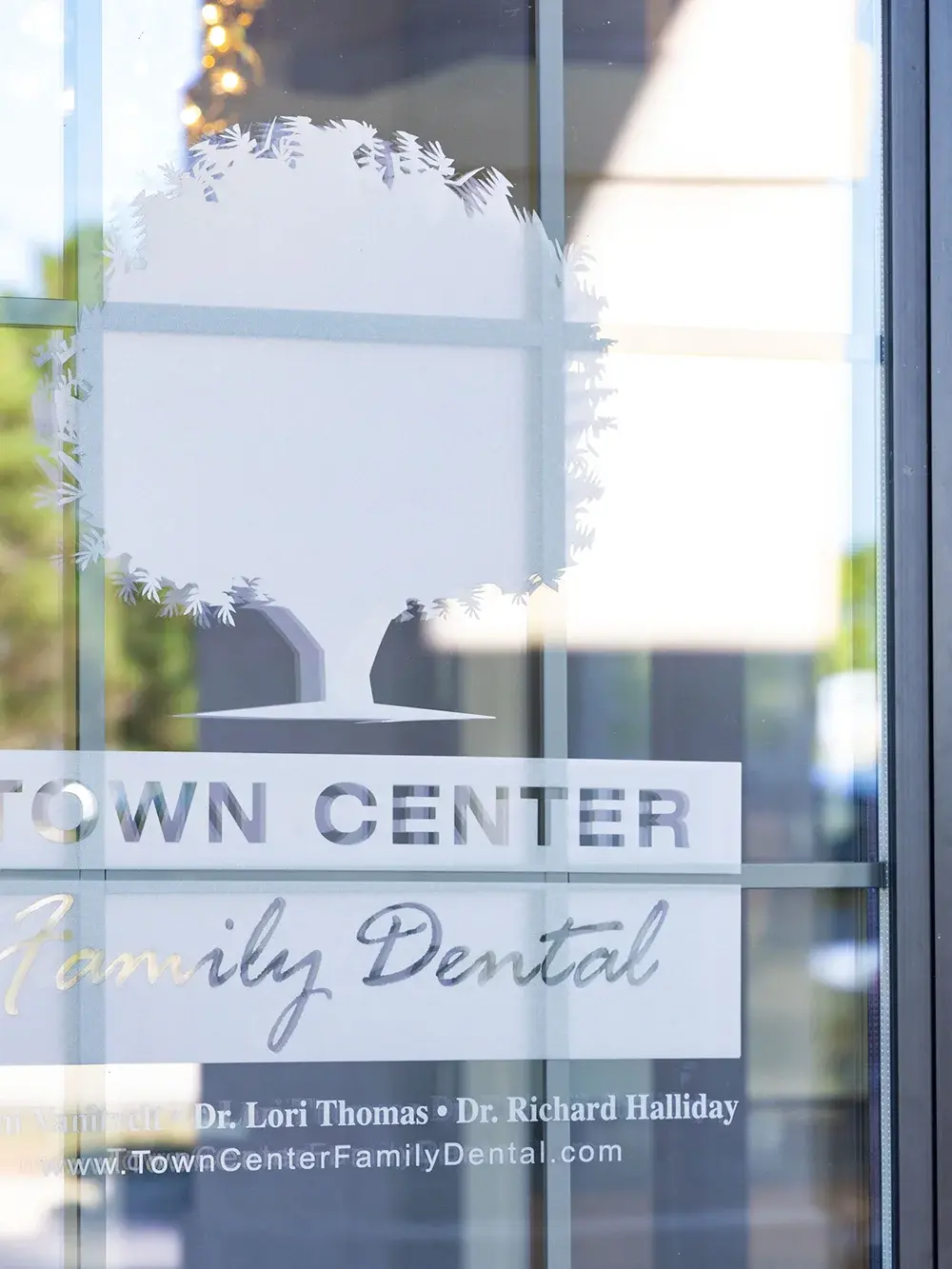 Town Center Family Dental logo on office window with frosted leaf design.