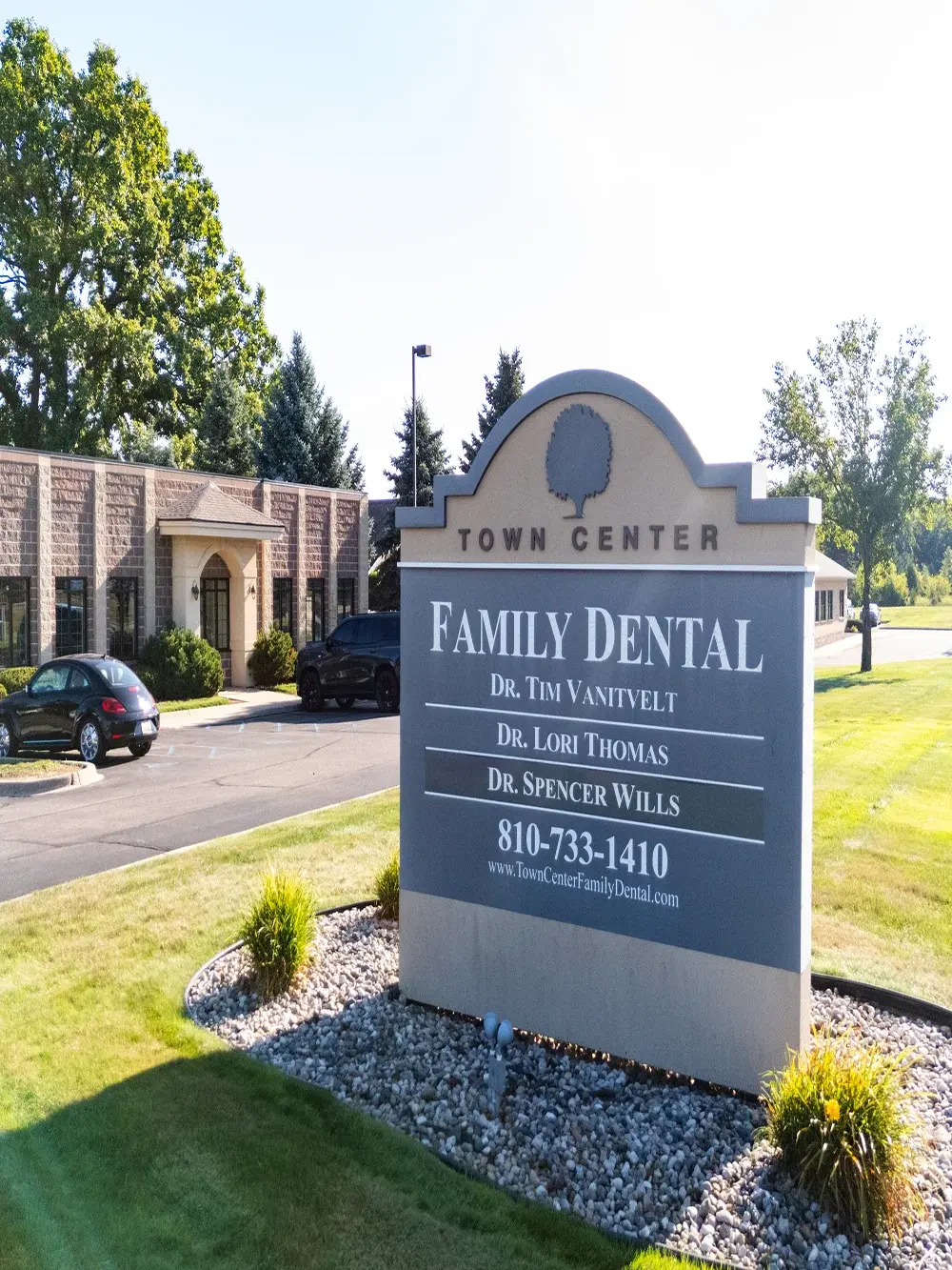 Town Center Family Dental office exterior sign with dentist names and contact information in Flint, Michigan.